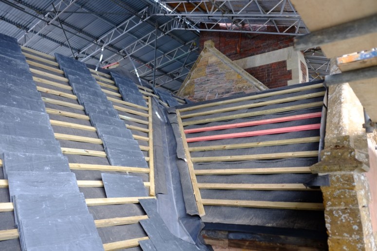 With the lead gullies complete and the protective lead layers embedded in the historic stone groves of the gables, the slates are ready to be hung. (Courtesy of Architectural Thread)