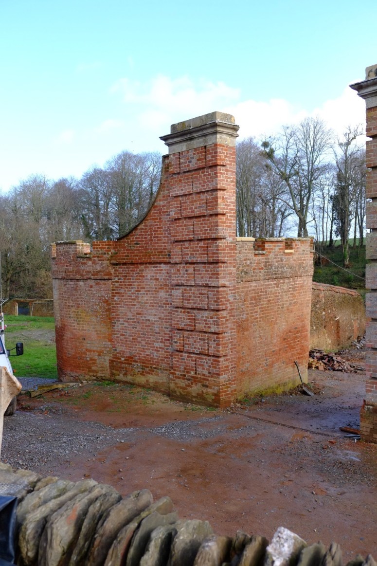 The northern most gate pillar, attached to what was the electricity sub-station from c.1950-2015, had a precipitous lean and had to be kept upright by scaffolding in order to keep it from collapsing completely. In 2015 this pillar we took this down brick by brick to its foundations so that essential repairs to re-straighten its angle could be undertaken. The pillar was then painstakingly re-built brick by brick in to their original positions and re-capped with its original stone entablature. The work carried out on this pillar included the complete restoration of the ‘Cider House’.