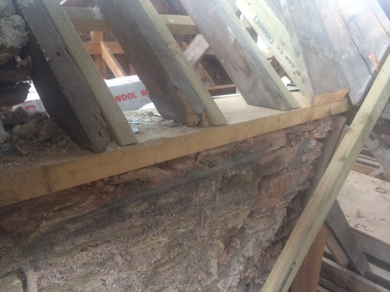 A new oak wall plate supporting older timbers on the c. 1900 gable, this is the east side and shows the stonework around the projecting mullioned window.