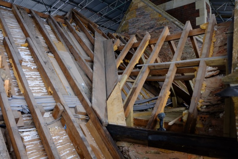 1. The gable straightened and restored and the wood and stone restorations complete, the voids between the rafters and the slates are prepared for insulation, felt and batons. (Courtesy of Architectural Thread.) 